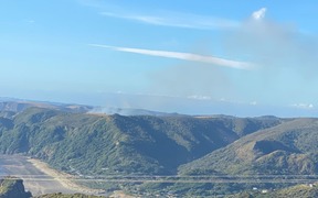 Seven people rescued after fire traps them at West Auckland beach