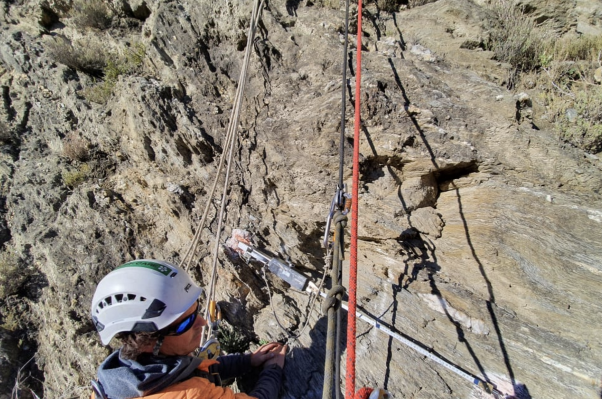 Abseiler at work hanging from remote cliffs, to keep highways open